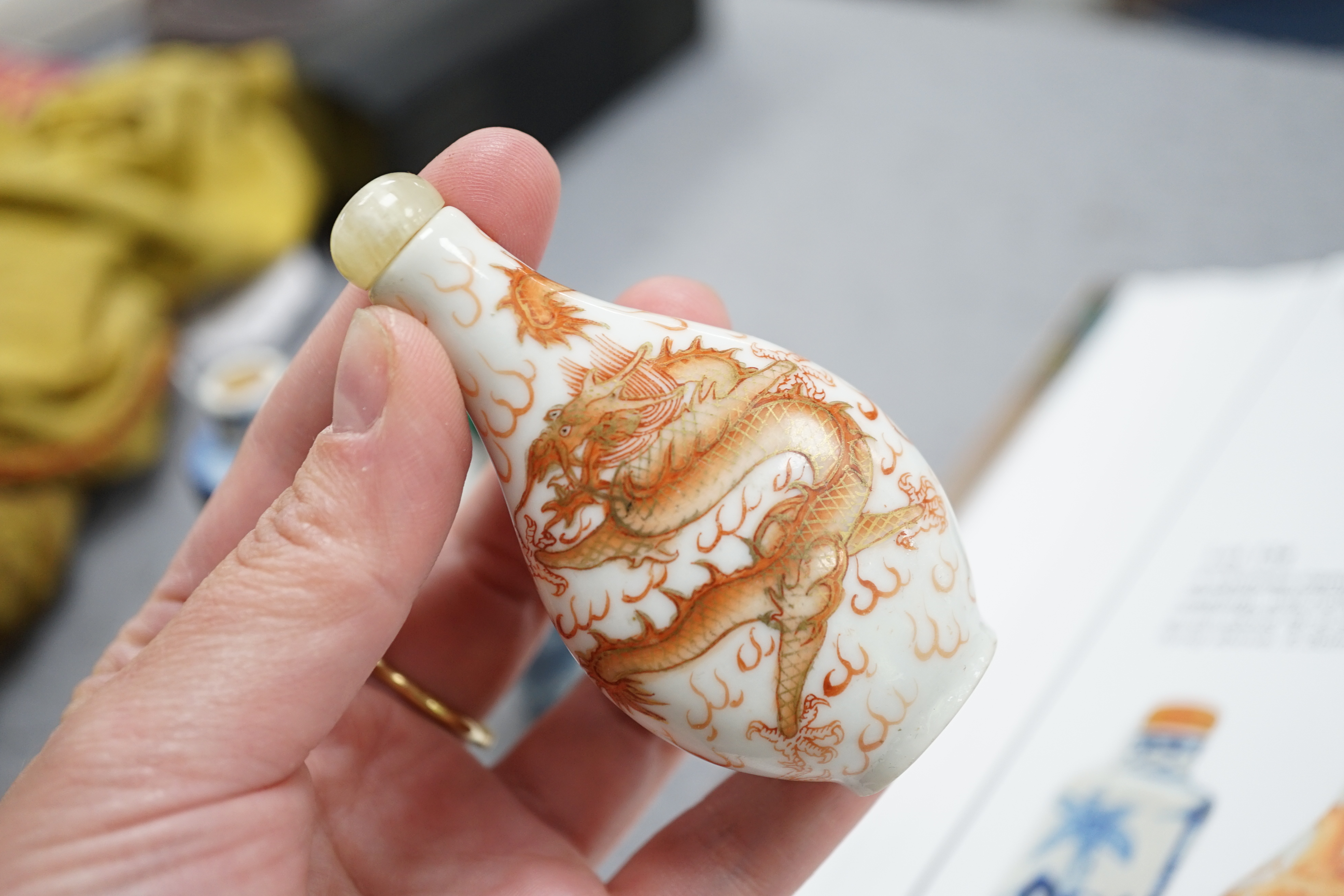 A Chinese iron red enamelled ‘dragon’ snuff bottle, Tongzhi mark and of the period (1862-74), together with two Chinese blue and white cylindrical snuff bottles, 19th century